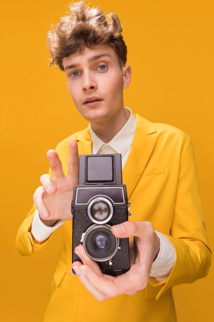 Portrait of fashionable boy filming with a camcorder