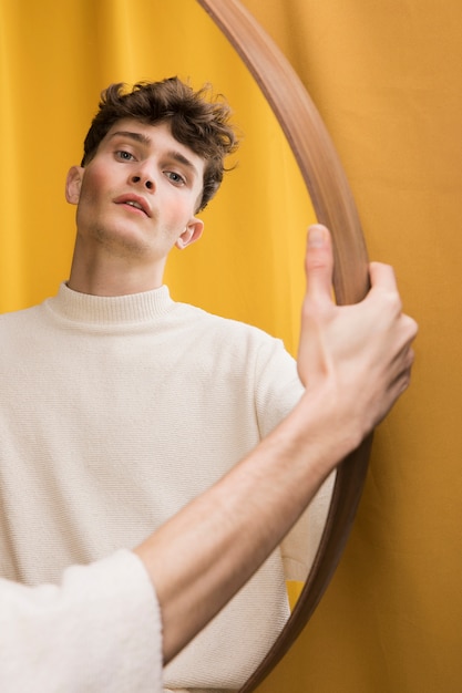 Portrait of fashionable boy in front of mirror