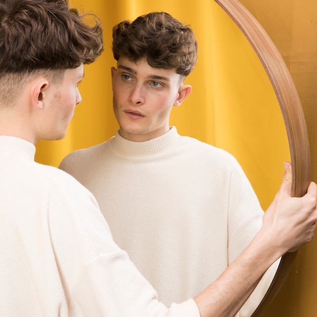 Free photo portrait of fashionable boy in front of mirror