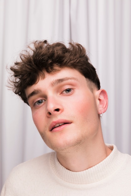 Portrait of fashionable boy in front of white curtain