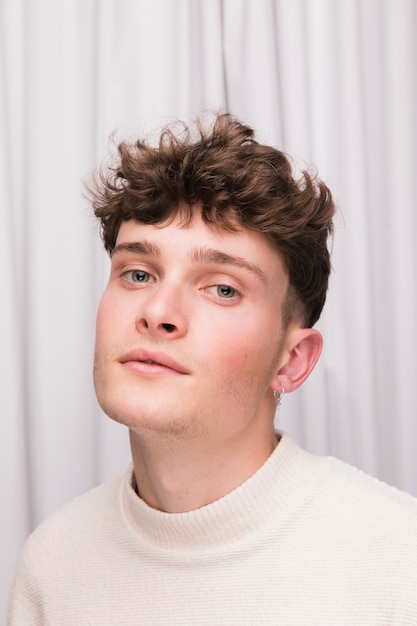 Free Photo portrait of fashionable boy in front of white curtain