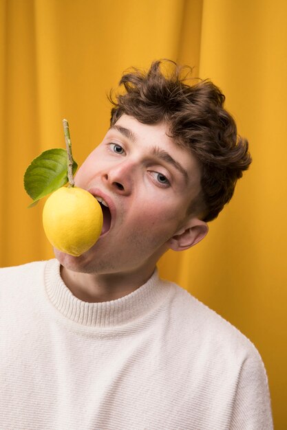 Portrait of fashionable boy with lemon