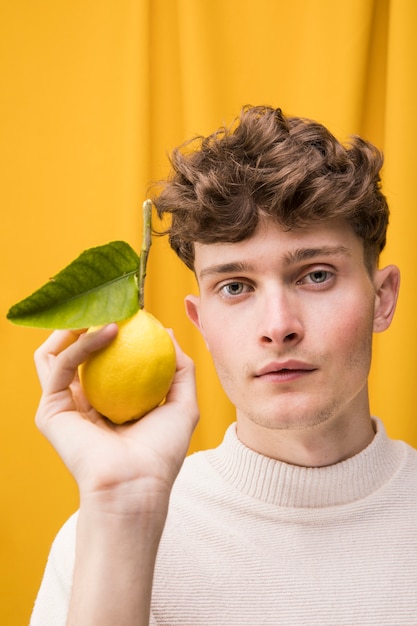 Portrait of fashionable boy with lemon