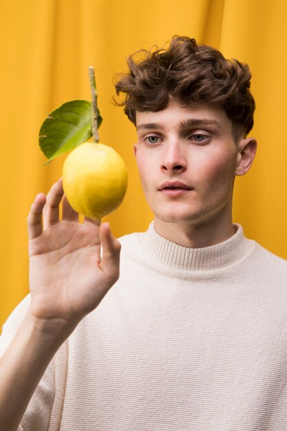 Portrait of fashionable boy with lemon