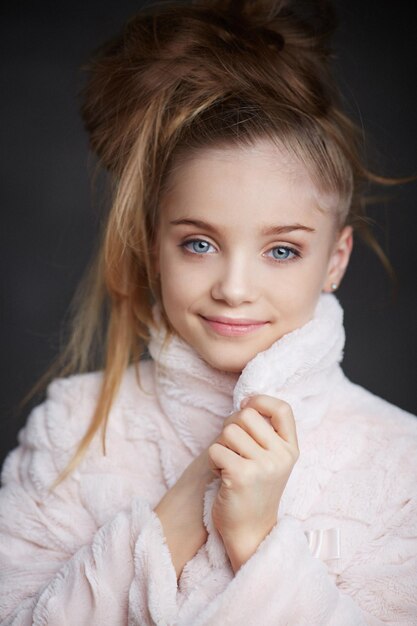 Portrait of fashionable young girl in white coat with long hair