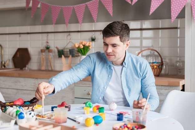 Free photo portrait of father painting eggs for easter