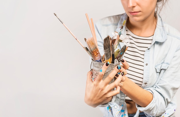 Free photo portrait of female artist with paintbrushes