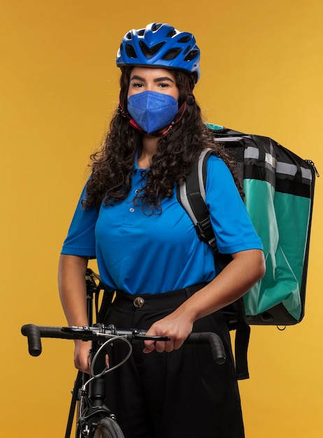 Portrait of female deliverer with bicycle and backpack