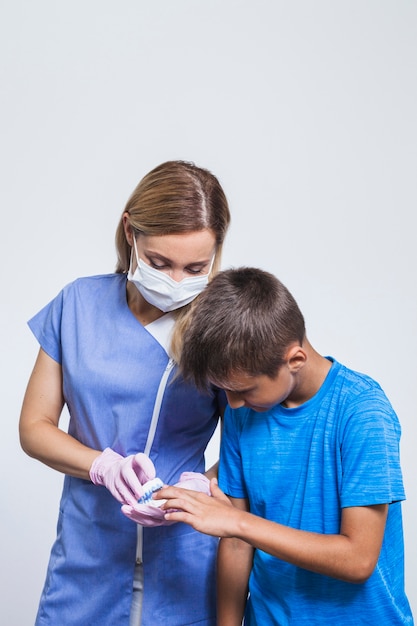 Portrait of female dentist and boy looking at teeth model