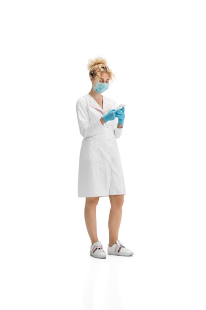 Free photo portrait of female doctor nurse or cosmetologist in white uniform and blue gloves over white