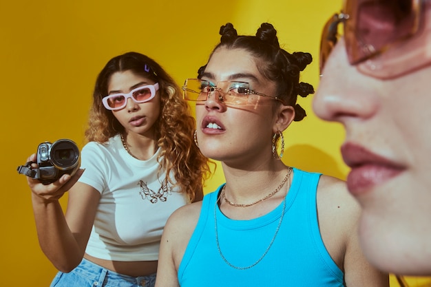 Portrait of female friends in 2000s fashion style posing together with camera