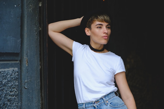 Portrait of female hipster with natural makeup and short haircut enjoying leisure time outdoors