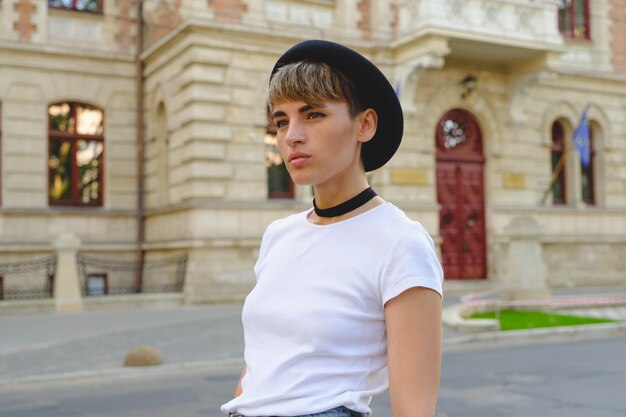 Portrait of female hipster with natural makeup and short haircut enjoying leisure time outdoors