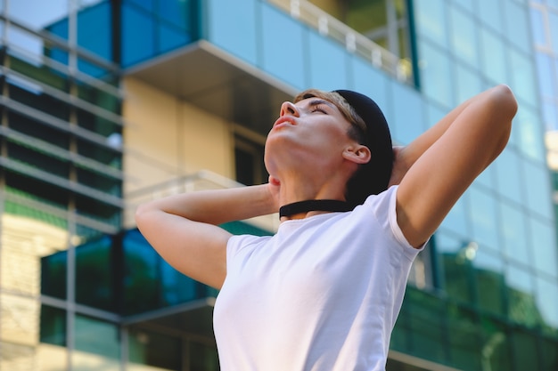 Portrait of female hipster with natural makeup and short haircut enjoying leisure time outdoors