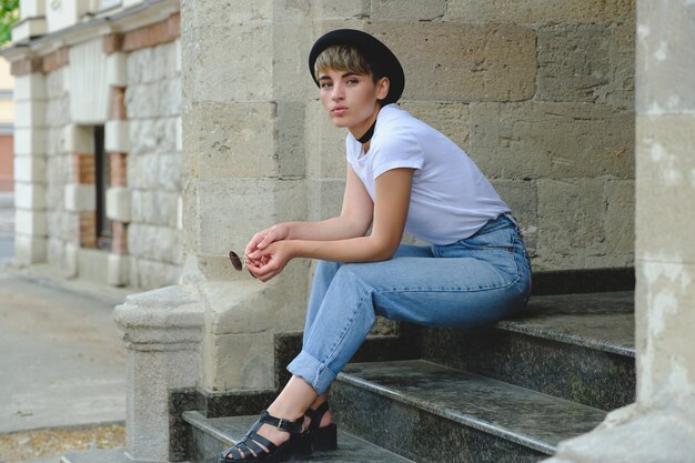 Portrait of female hipster with natural makeup and short haircut enjoying leisure time outdoors