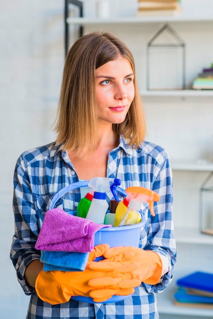 Free photo portrait of female janitor holding cleaning equipment in the bucket