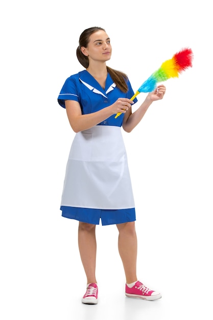 Portrait of female made, housemaid, cleaning worker in white and blue uniform isolated over white