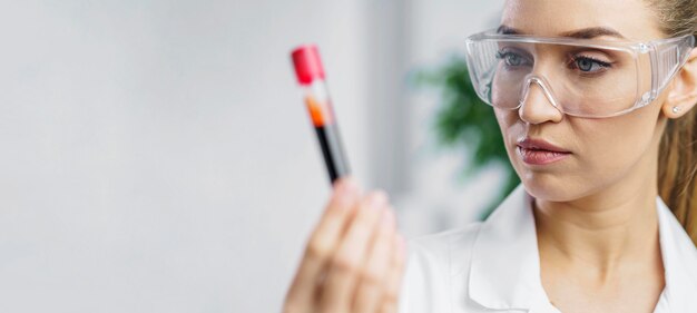 Portrait of female researcher in the lab with test tube and copy space