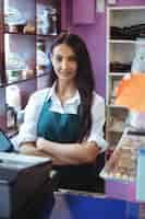 Free photo portrait of female shopkeeper standing at turkish sweets counter