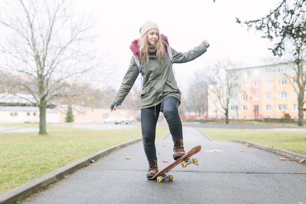 Free photo portrait of female skateboarder on walkway