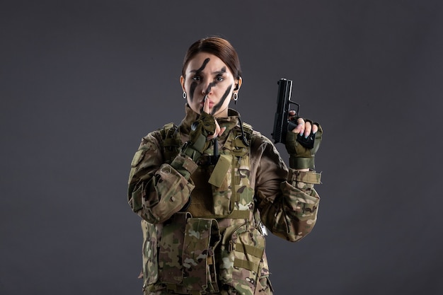 Free Photo portrait of female soldier in camouflage with gun dark wall