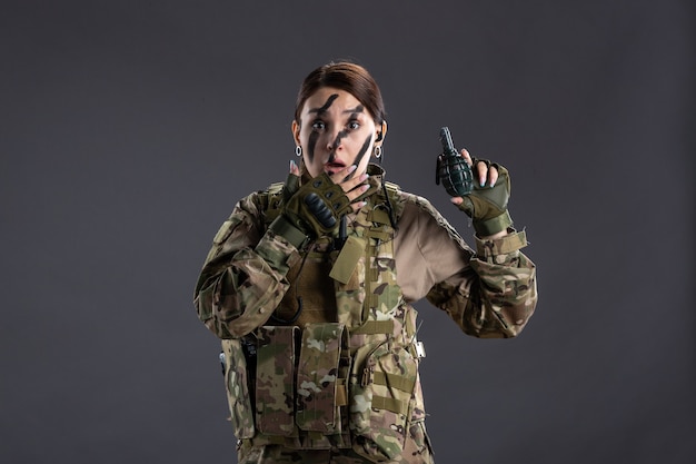 Free Photo portrait of female soldier with grenade in her hands dark wall