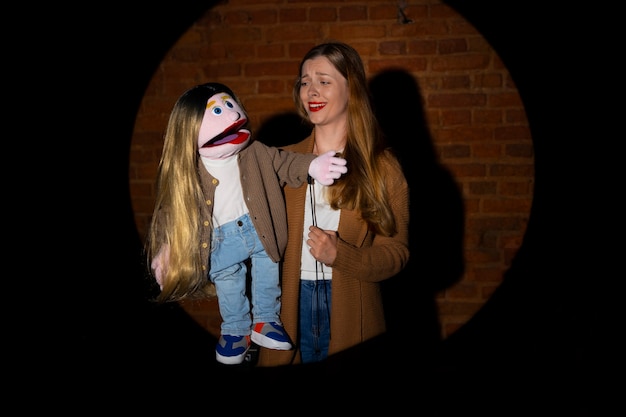 Free photo portrait of female ventriloquist with puppet at show