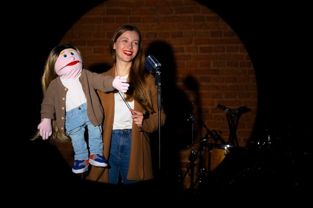 Free photo portrait of female ventriloquist with puppet at show