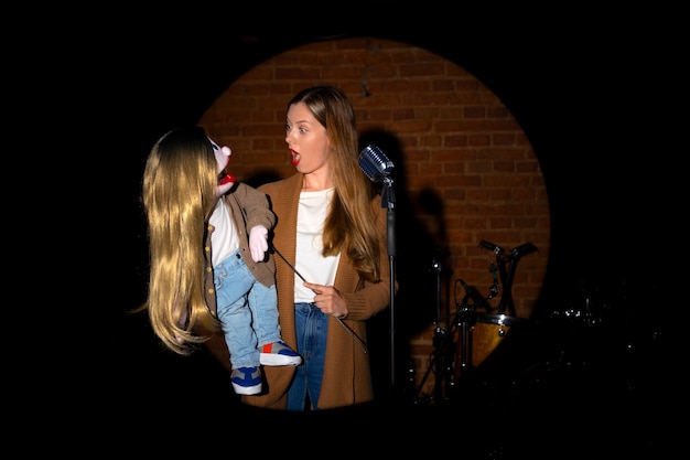 Free photo portrait of female ventriloquist with puppet at show