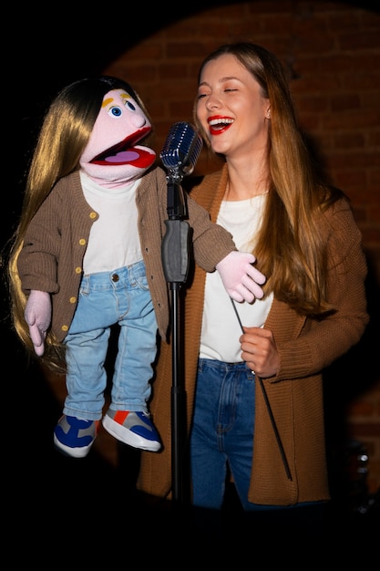 Free photo portrait of female ventriloquist with puppet at show