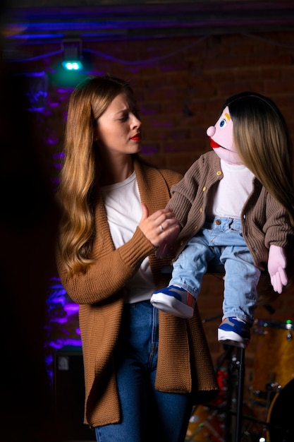 Free photo portrait of female ventriloquist with puppet at show