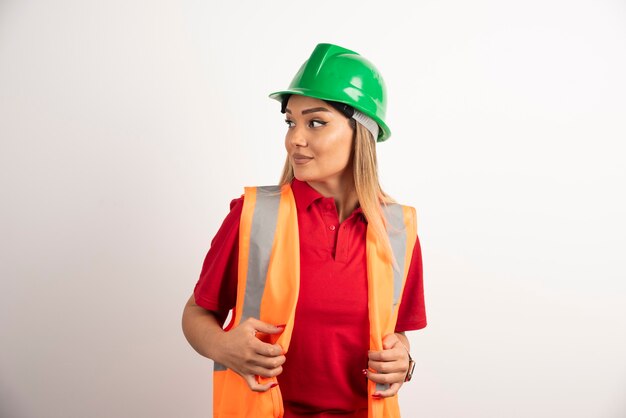 Portrait of a female worker posing with helmet on white background.