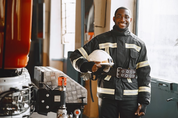 Portrait of a firefighter standing in front of a fire engine