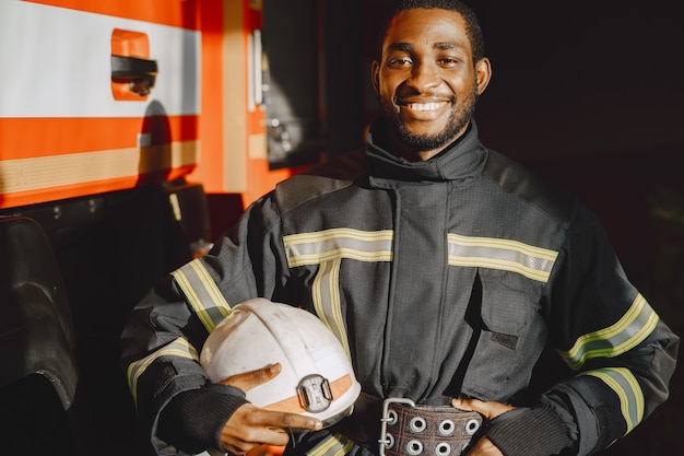 Portrait of a firefighter standing in front of a fire engine