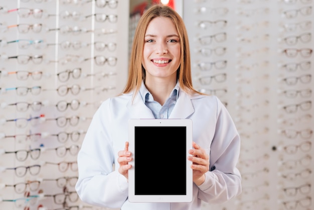 Portrait of friendly female optometrist showing tablet template