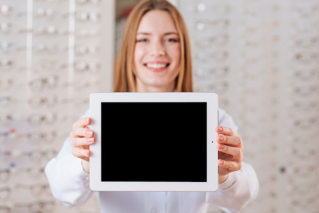 Free Photo portrait of friendly female optometrist showing tablet template