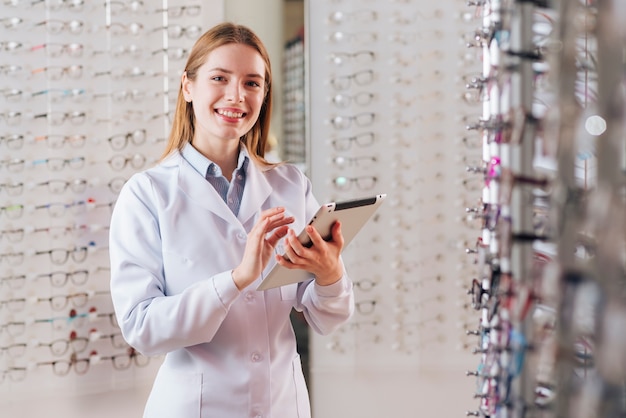 Portrait of friendly female optometrist using tablet