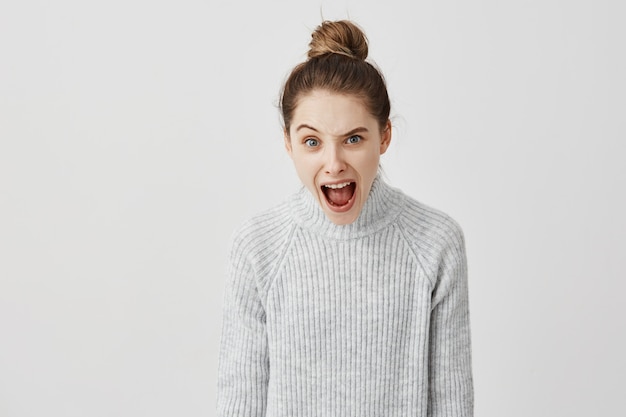 Free photo portrait of furious woman shouting raising one eyebrow. nervous reaction of female casting director screaming in disagreement. emotions concept