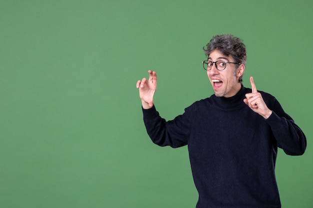 Portrait of genius man dressed casually in studio shot green wall