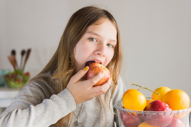 Portrait of a girl eating red apple