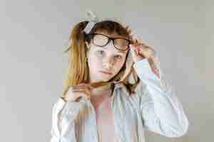 Free photo portrait of a girl holding eyeglasses