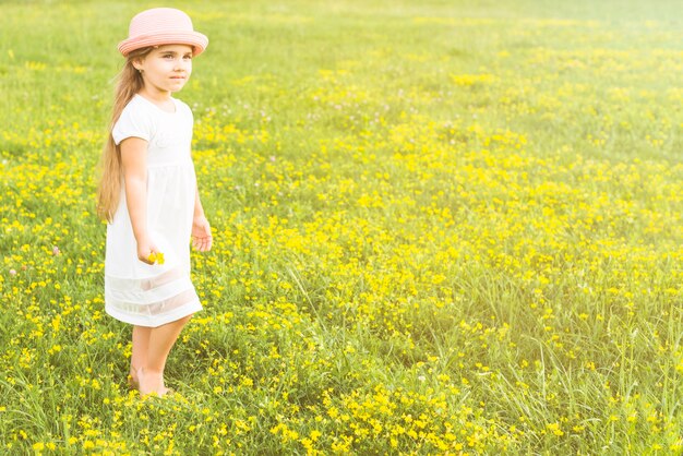 Portrait of a girl holding flowers in hand standing in the meadow