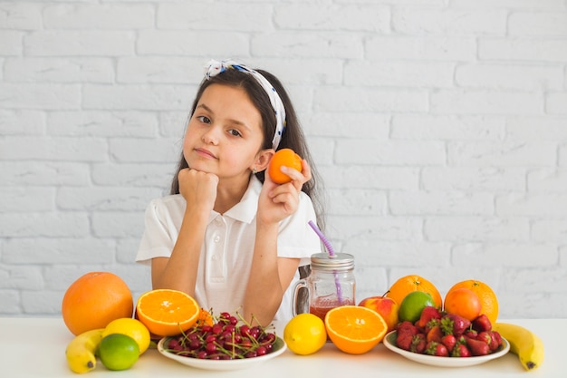 Free photo portrait of girl holding ripe fruit