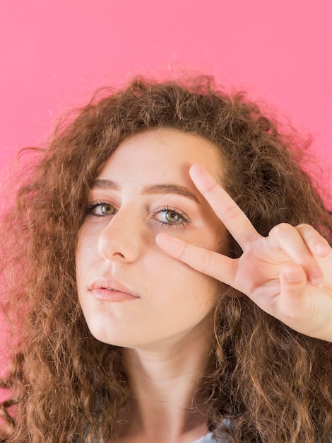 Free Photo portrait of girl showing peace sign