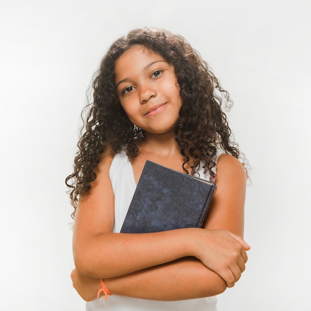 Free photo portrait of a girl with book folding her arms