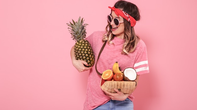 Free photo portrait of a girl with healthy food, fruits, on a pink wall