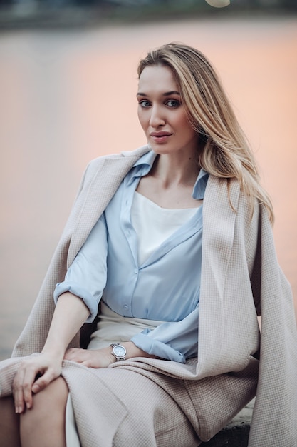 Portrait of gorgeous woman sitting near the lake