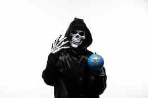 Free photo portrait of grim reaper in black clothes with little globe on white