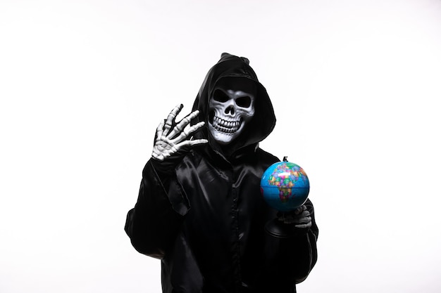 Free Photo portrait of grim reaper in black clothes with little globe on white