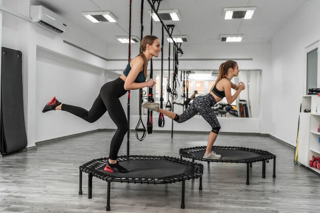 Portrait of a group two girls in gymnastics fitness trampolines in the gym